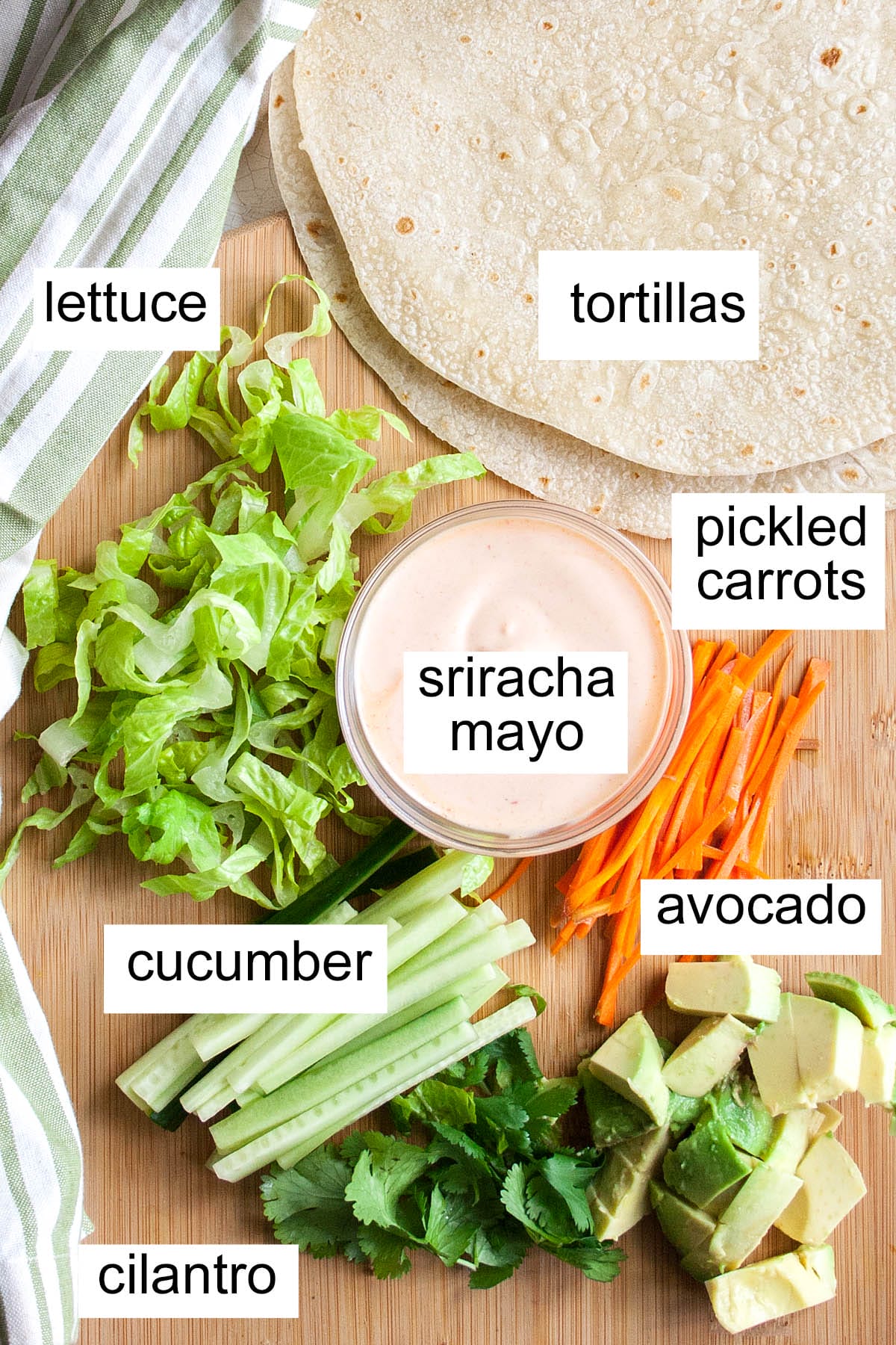 Spicy veggie wrap ingredients on a cutting board with labels.