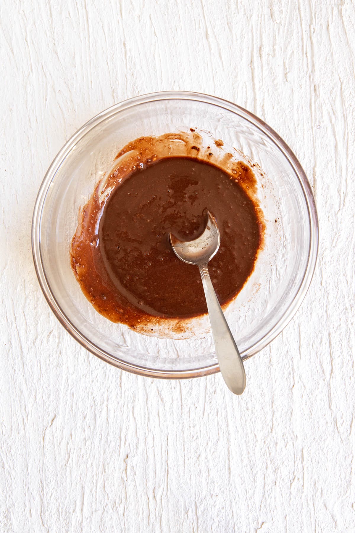 Mixed ingredients in a bowl with spoon.
