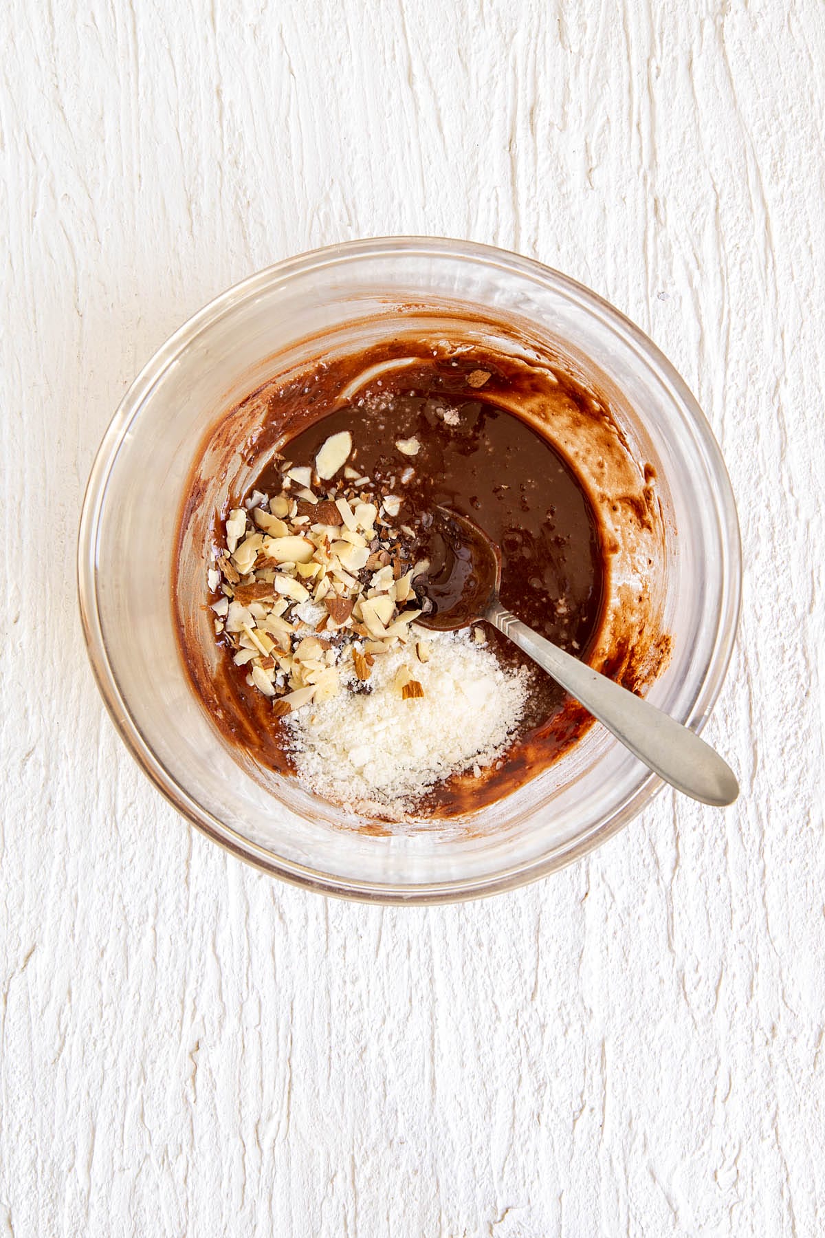 Sliced almonds and shredded coconut added to the bowl.