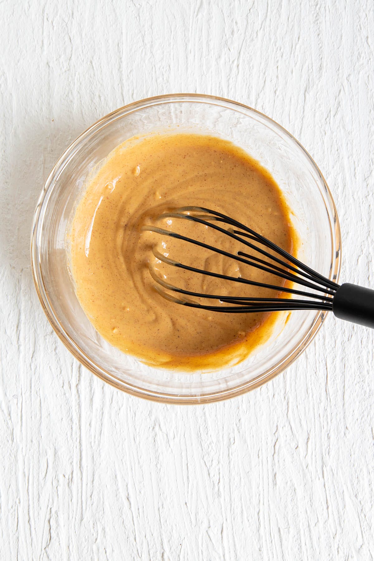 Peanut sauce in a large mixing bowl with whisk.