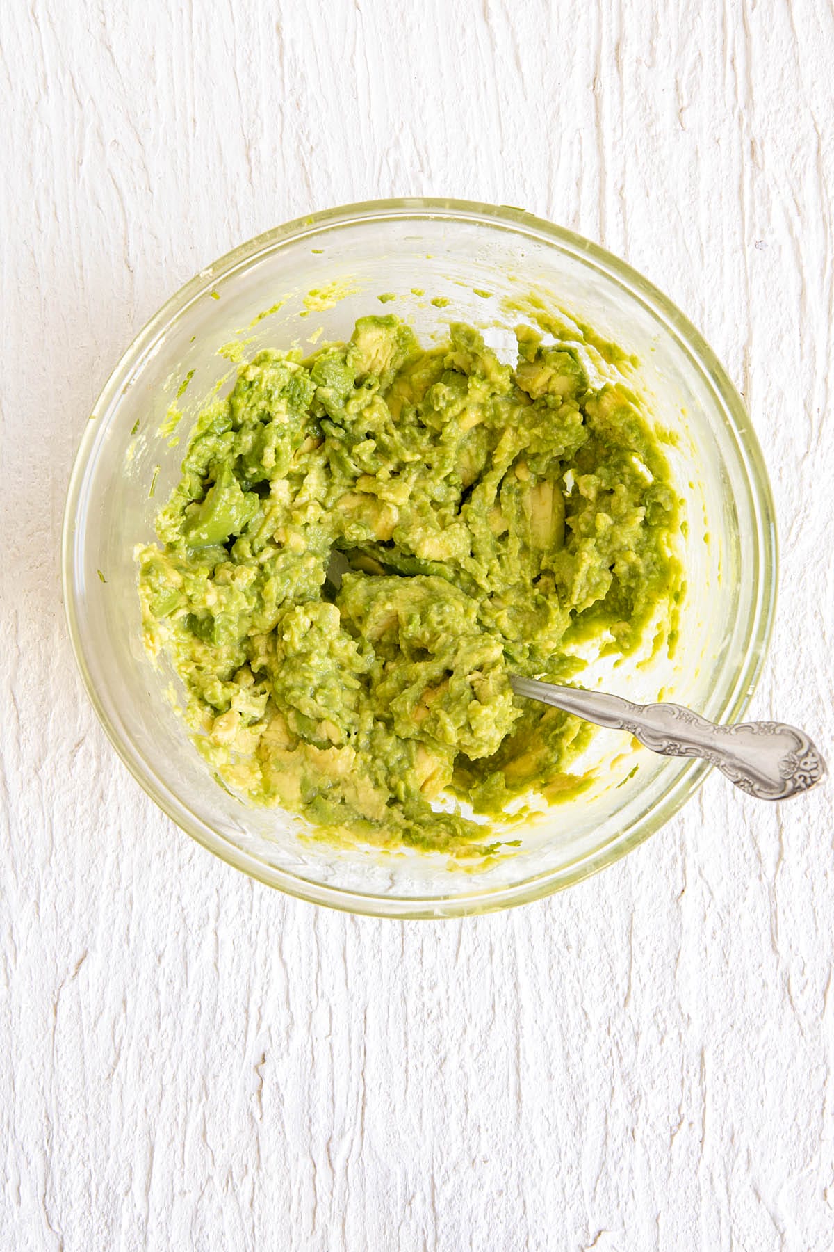 Mashed avocados in a mixing bowl.