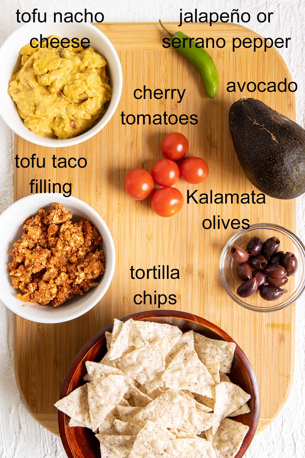 Nacho ingredients on a cutting board with labels.