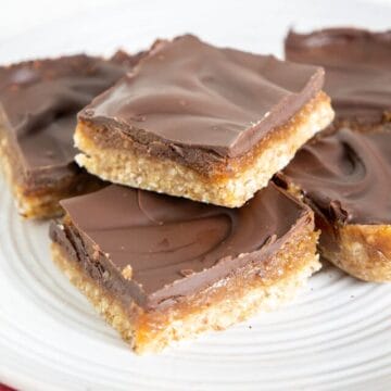 These No-Bake Chocolate Peanut Butter Caramel Bars are sweet and rich. Made with dates and maple syrup, there's no refined sugar. on a plate.