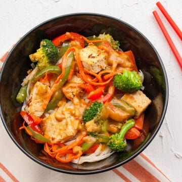 Sesame Ginger Tofu with Thai Noodles in a bowl with chopsticks.