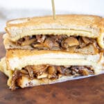 Vegan Caramelized Onion and Mushroom Grilled Cheese on a cutting board.