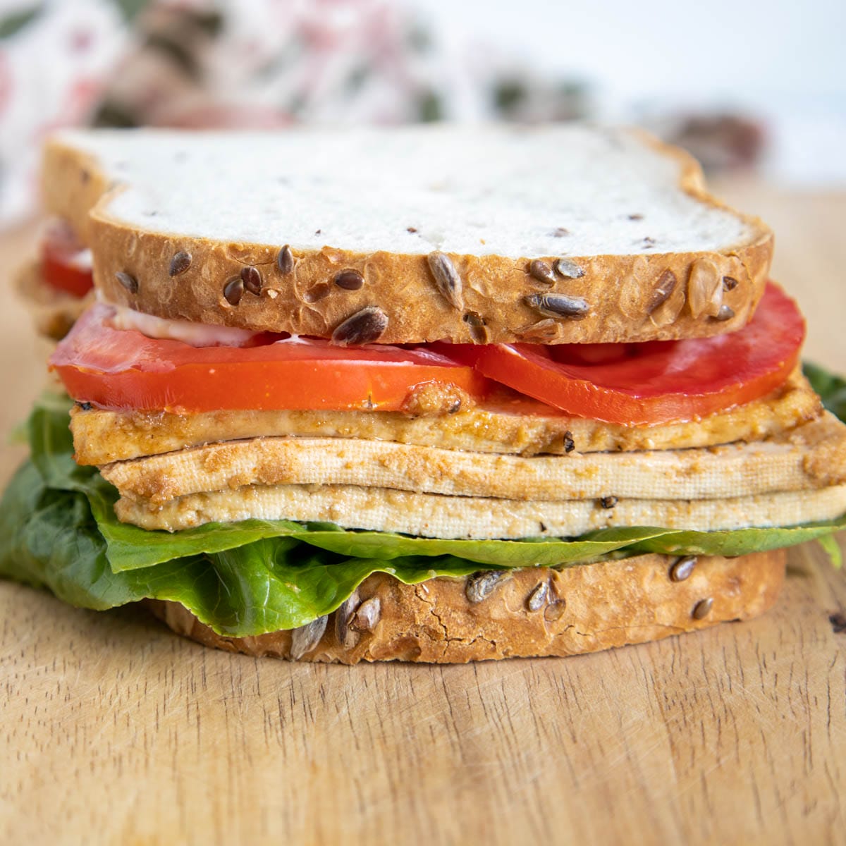 Vegan Lunch Meat in a sandwich on a cutting board.