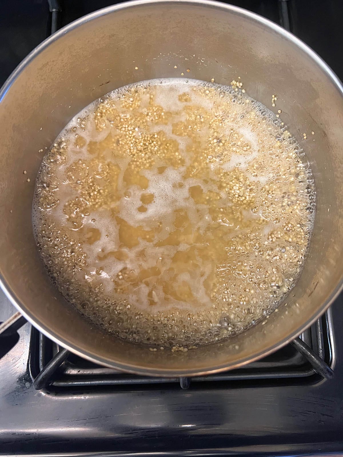 Boiling water and quinoa in a saucepan.