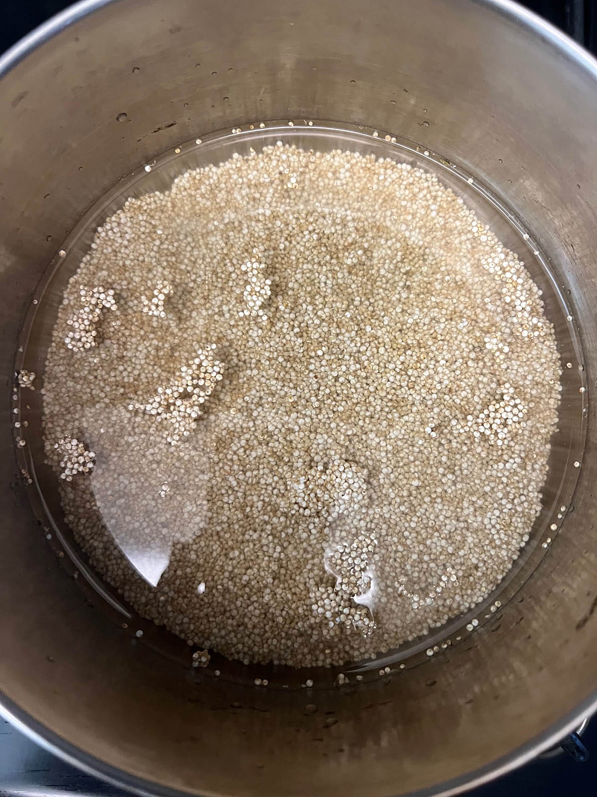 Quinoa and water in a saucepan.