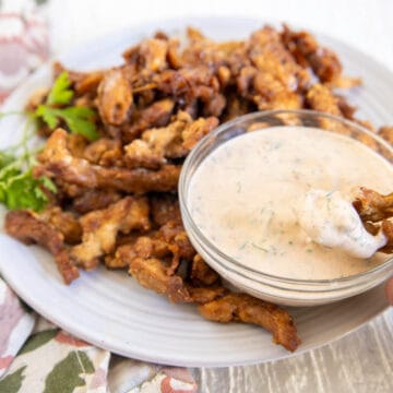 Popcorn soy curl being dunked into chipotle ranch.