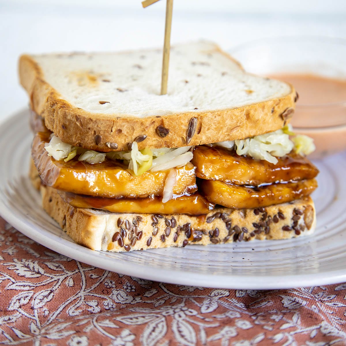 This Vegan Teriyaki Reuben has a sweet teriyaki sauce, spicy raw sauerkraut, and a spicy thousand island dressing. Vegan Teriyaki Reuben on a plate.