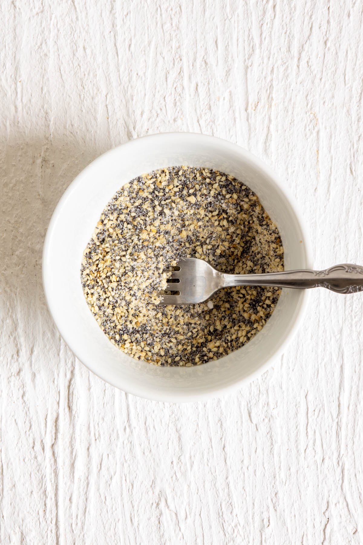 Everything bagel mixture in a small bowl with fork.