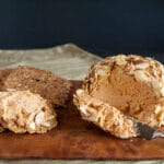 Sun-Dried Tomato and Basil Vegan Cheese Ball on cutting board with crackers.