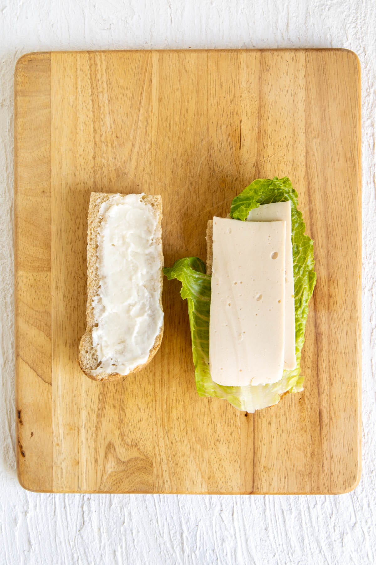 Toasted baguette with lettuce and vegan mozzarella on top.