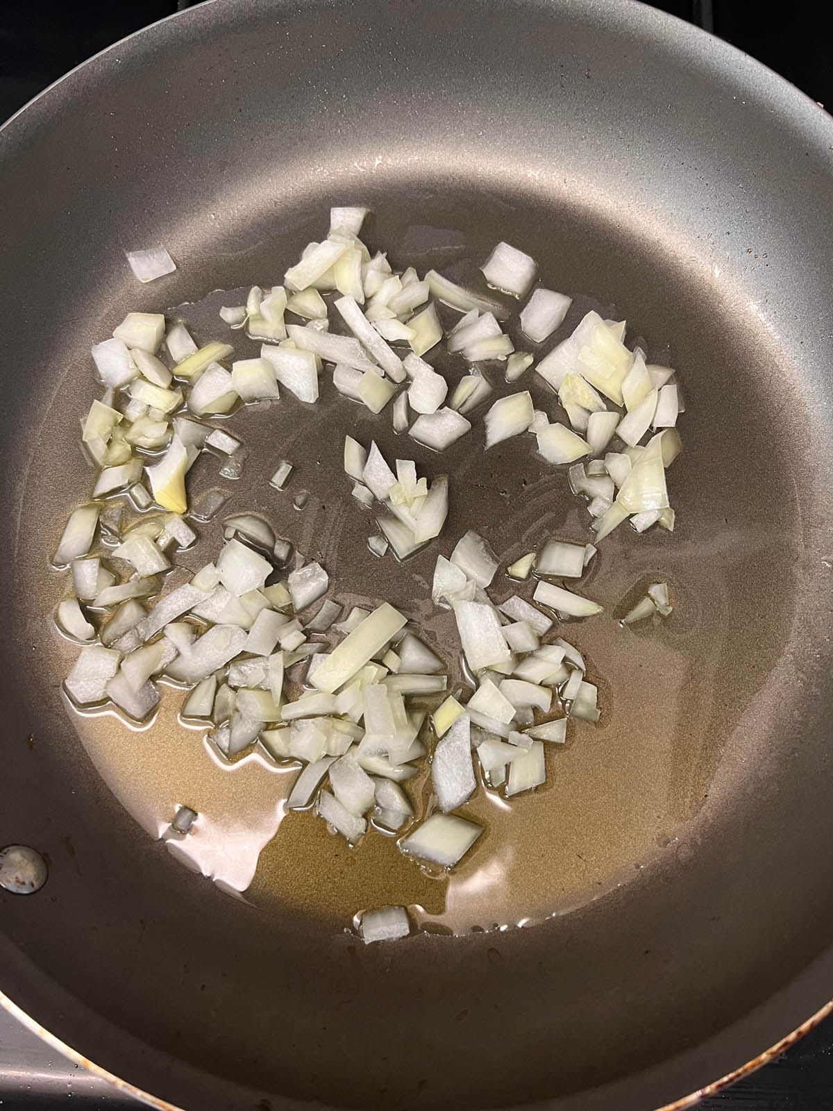 Cooked chopped onions in a skillet.