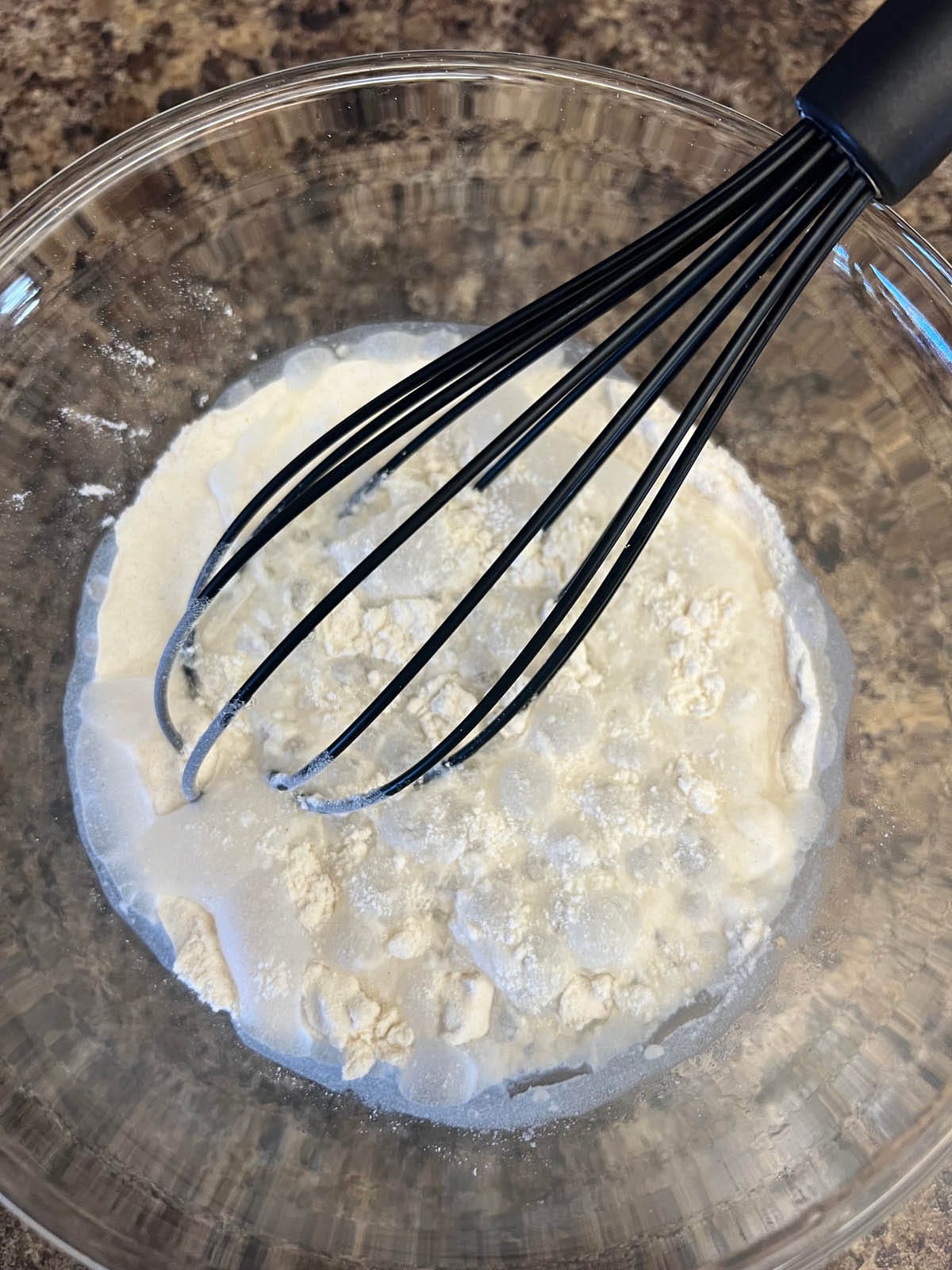 Rice flour, salt, and sparkling water in a mixing bowl with whisk.
