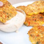 Vegetable fritter bring dipped into vegan chipotle ranch dressing.