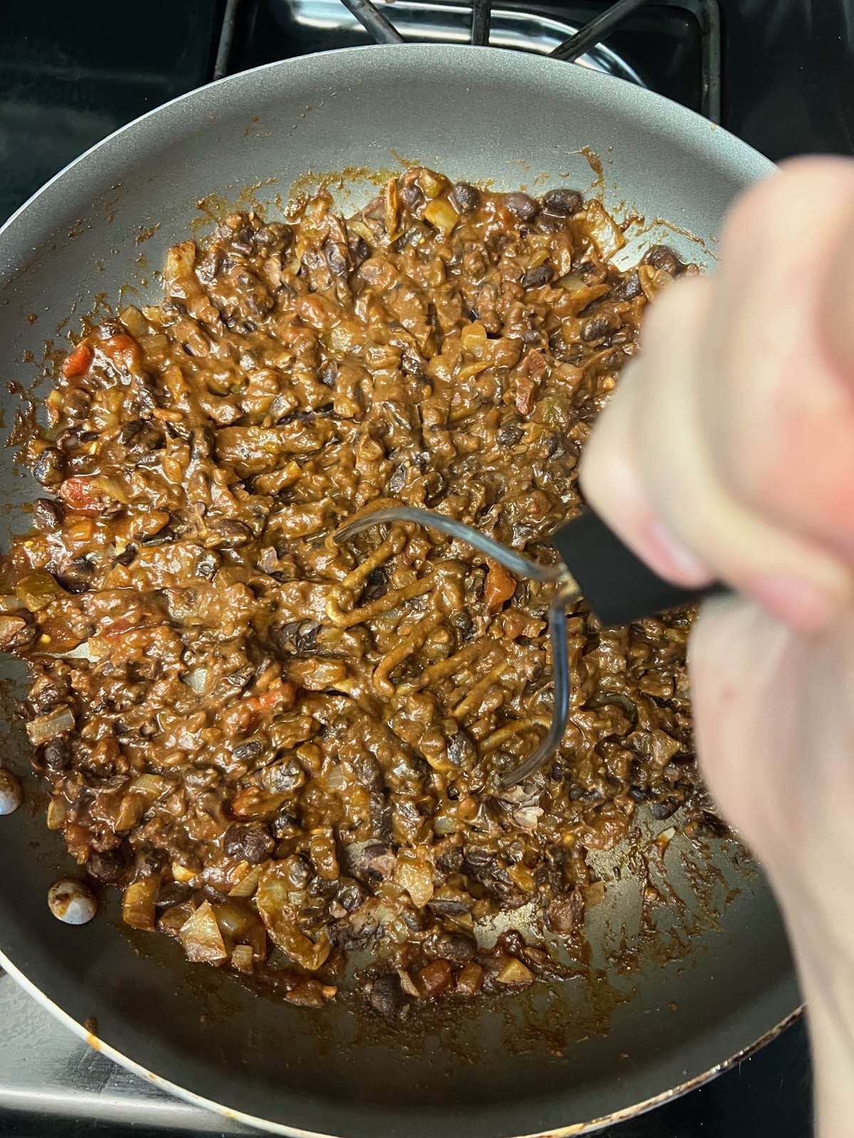 Black bean mixture being mashed.