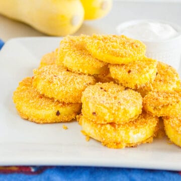 Fried Squash on a plate with yellow squash in the background.