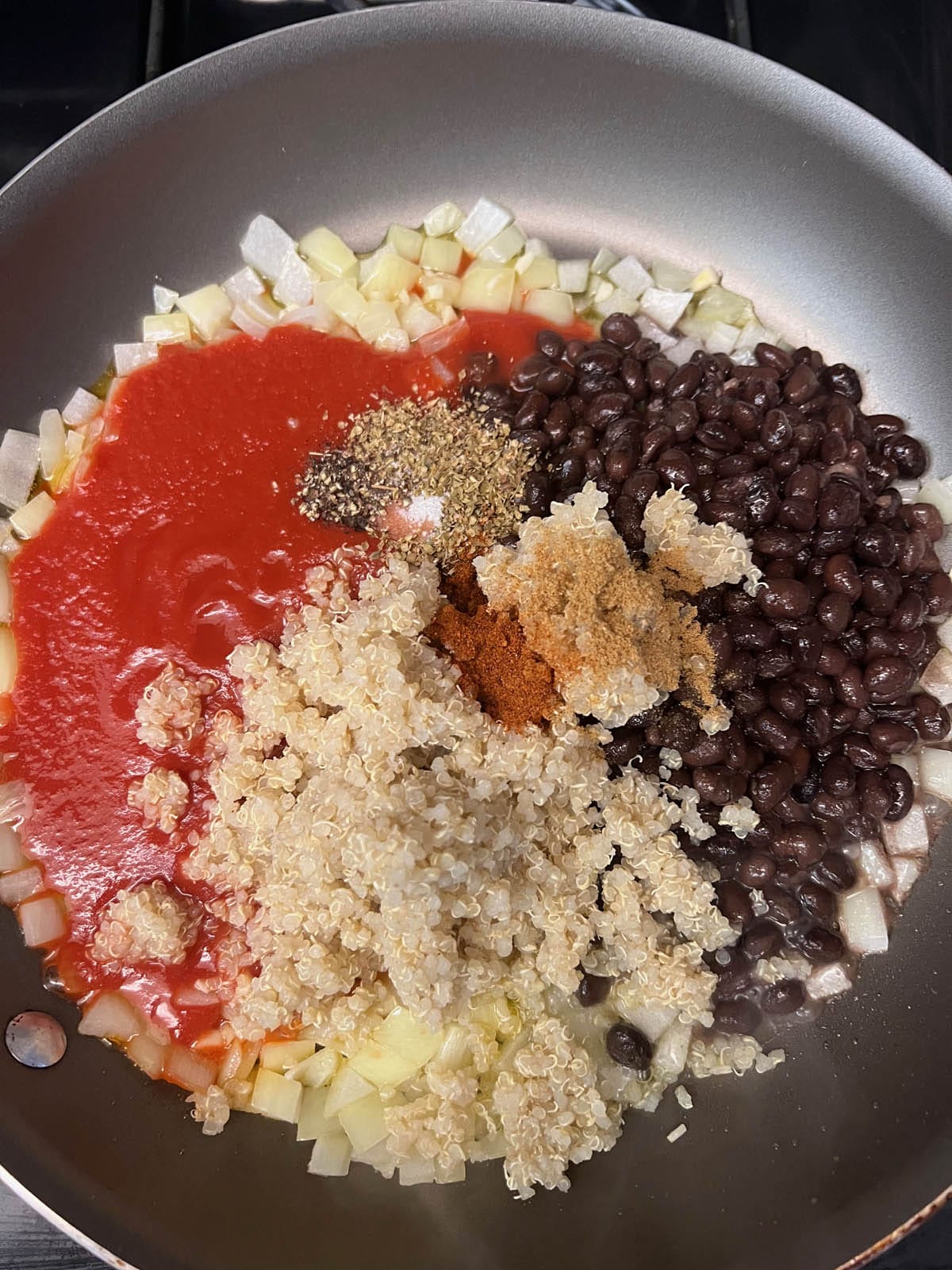 Black beans, tomato sauce, and spices added to the pan.