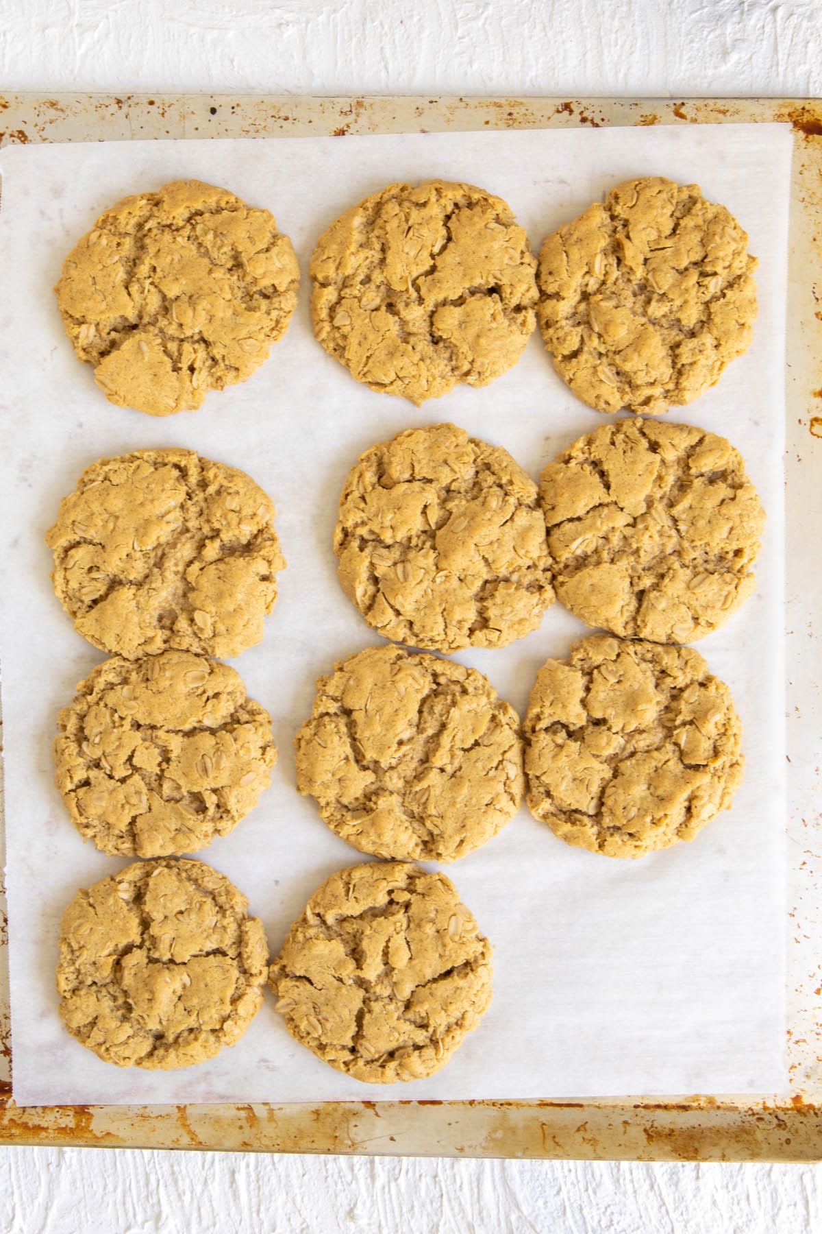 Vegan Oatmeal Cookies on a parchment paper lined baking sheet.