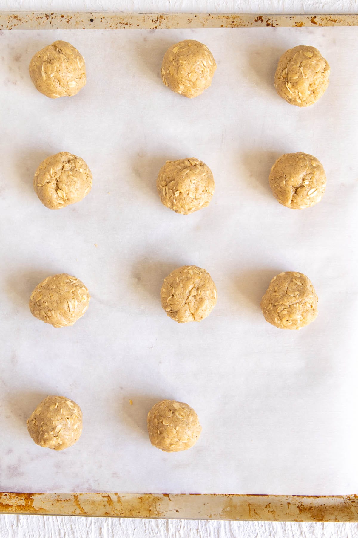 Dough balls on a parchment paper lined baking sheet.