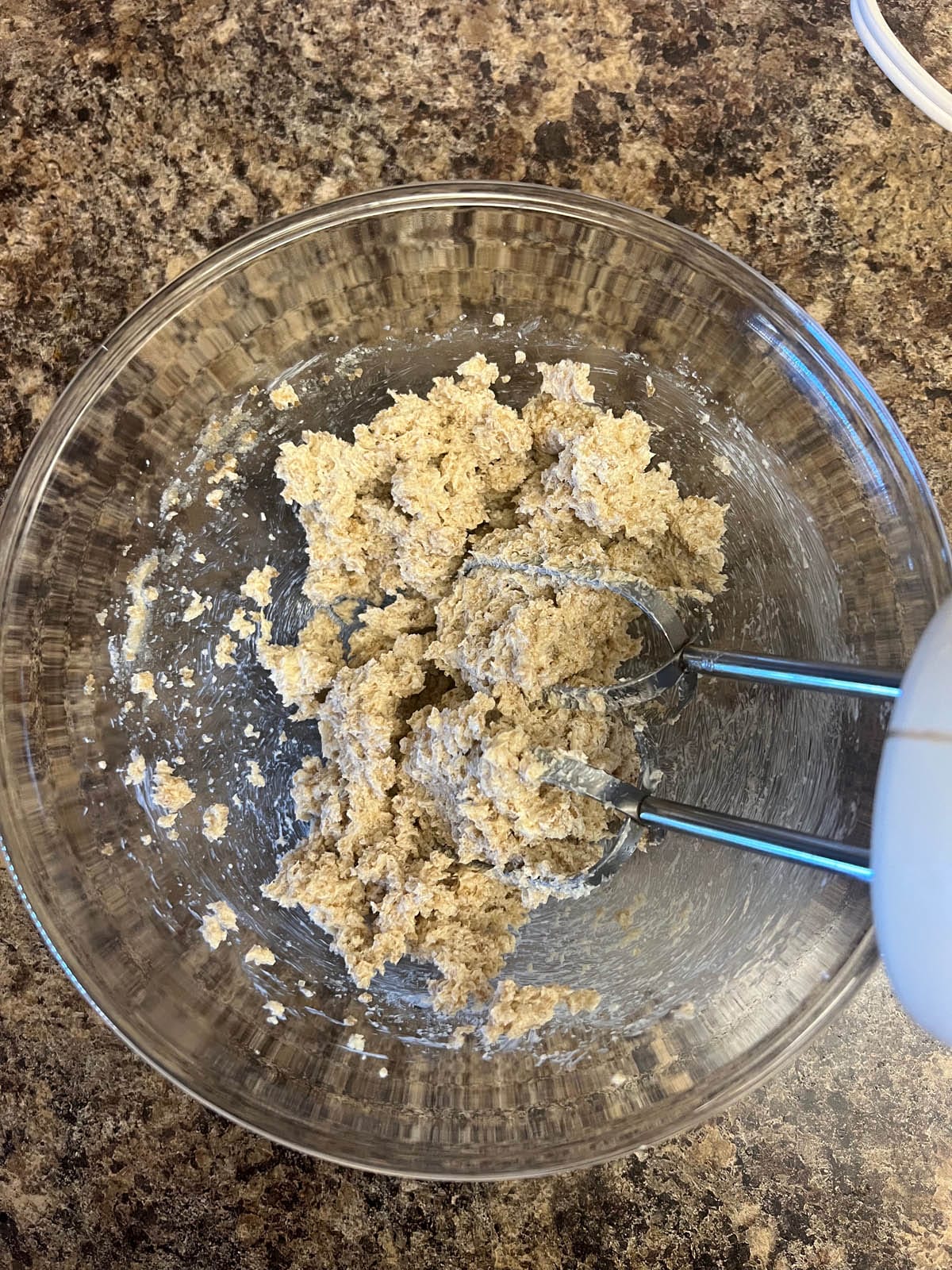 Wet ingredients mixed in a bowl with handheld mixer.