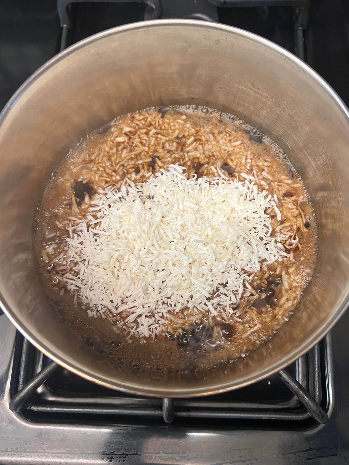 Shredded coconut added to the saucepan.
