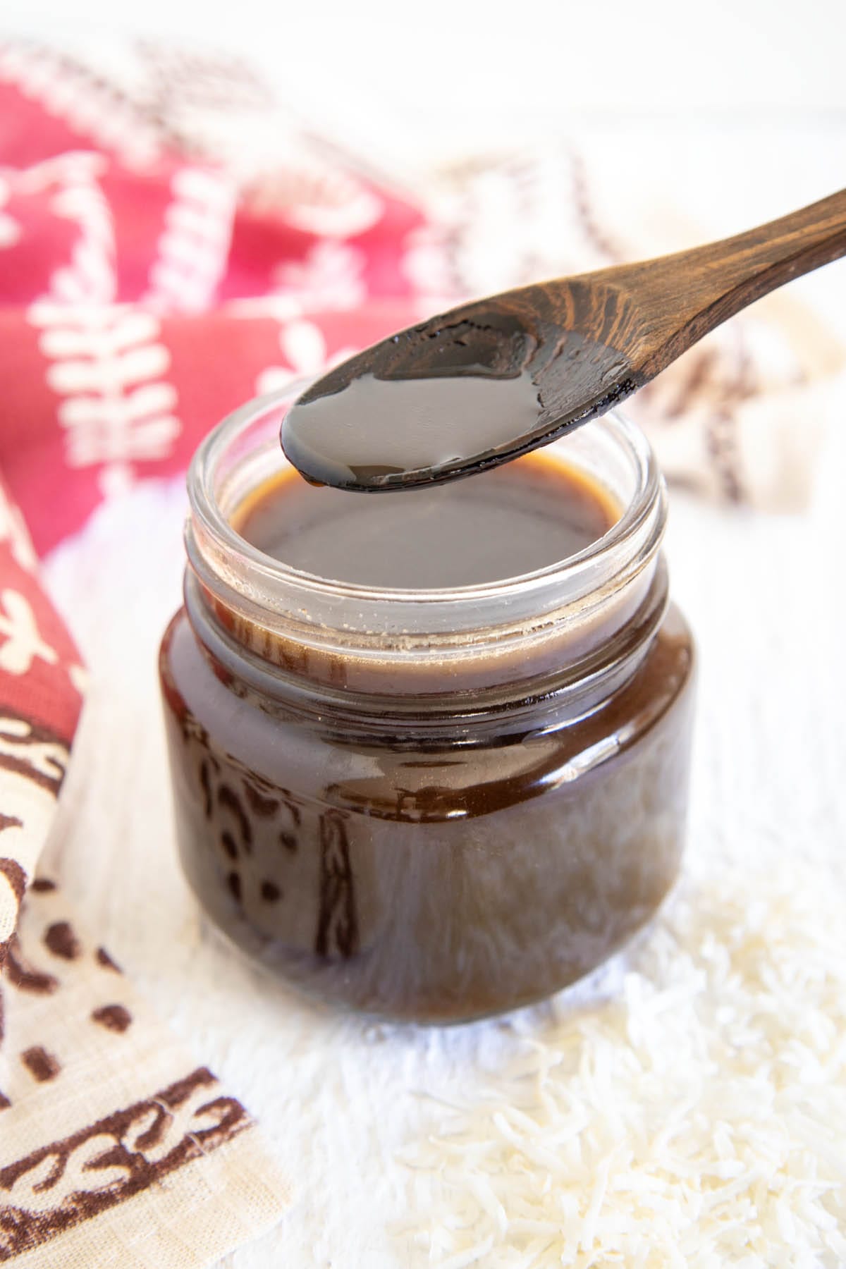 Spoonful of Coconut Simple Syrup above mason jar.