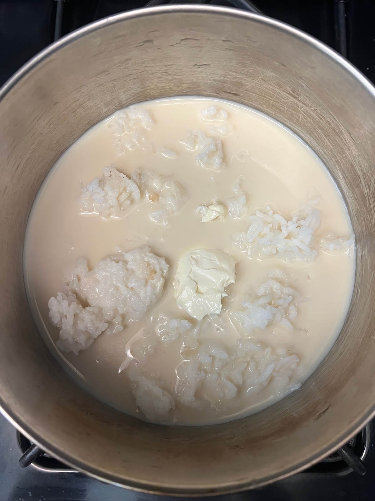 Soy milk, vegan butter, and cooked rice in a saucepan.