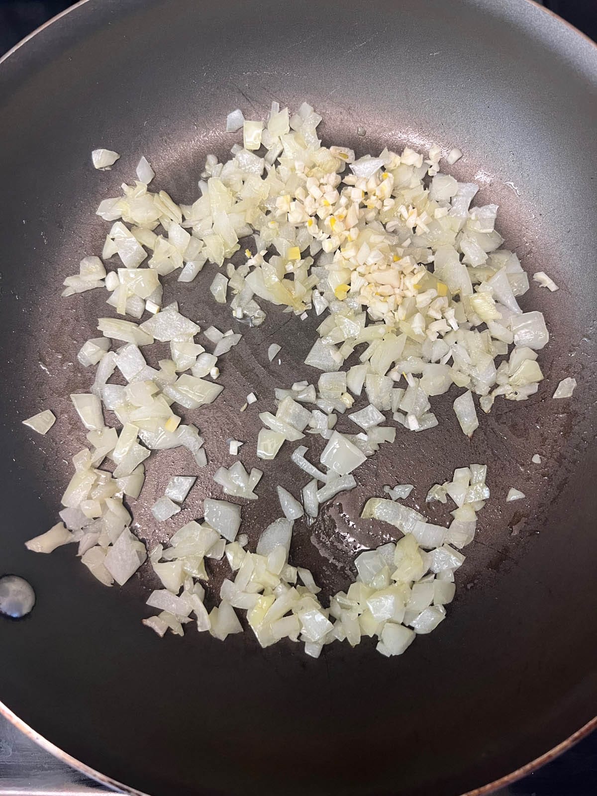 Minced garlic added to the pan of chopped onions.