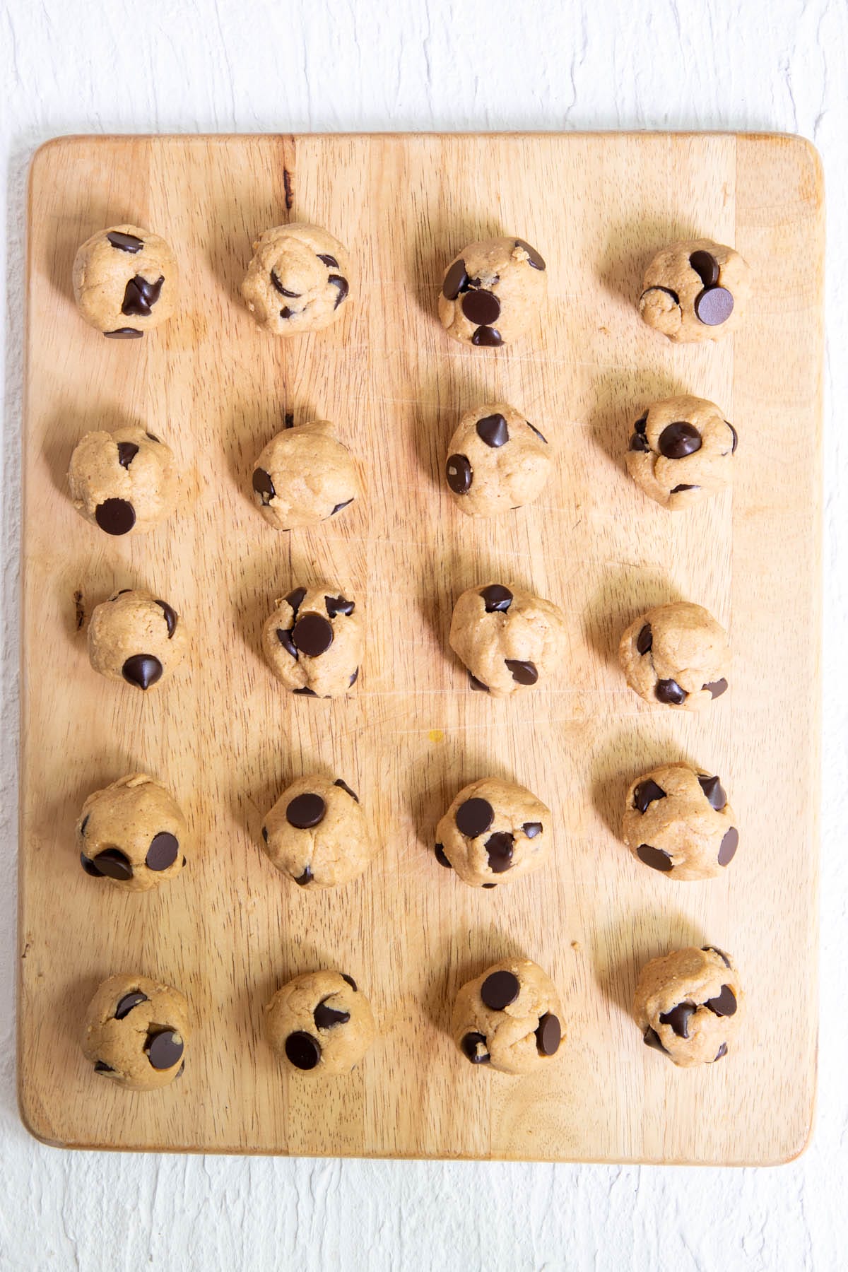 Protein balls with protein powder on a cutting board.