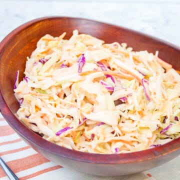 Sriracha Coleslaw in a wood bowl with fork.