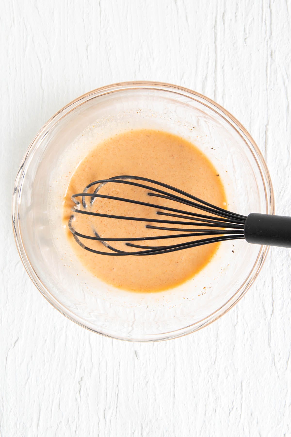 Sriracha coleslaw dressing ingredients in a bowl after mixing.