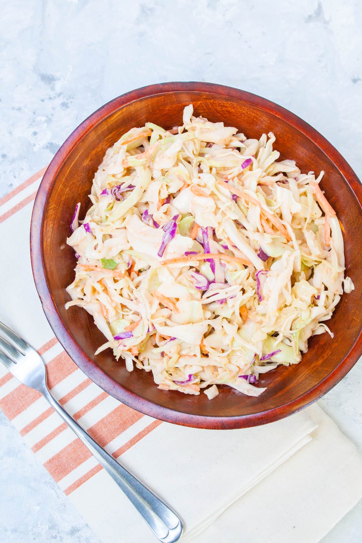 Sriracha Coleslaw in a wood bowl with fork.